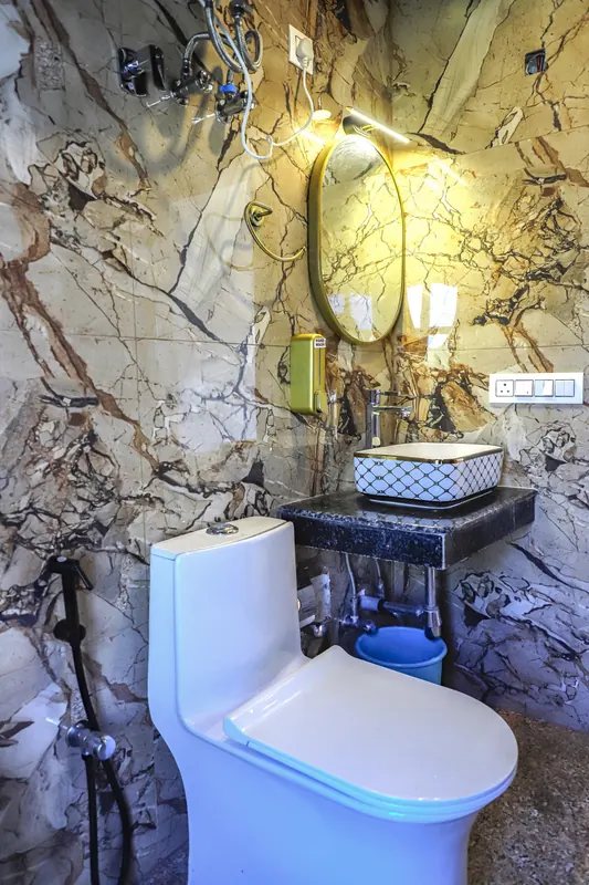 Bathroom with stone-pattern walls and backlit mirror