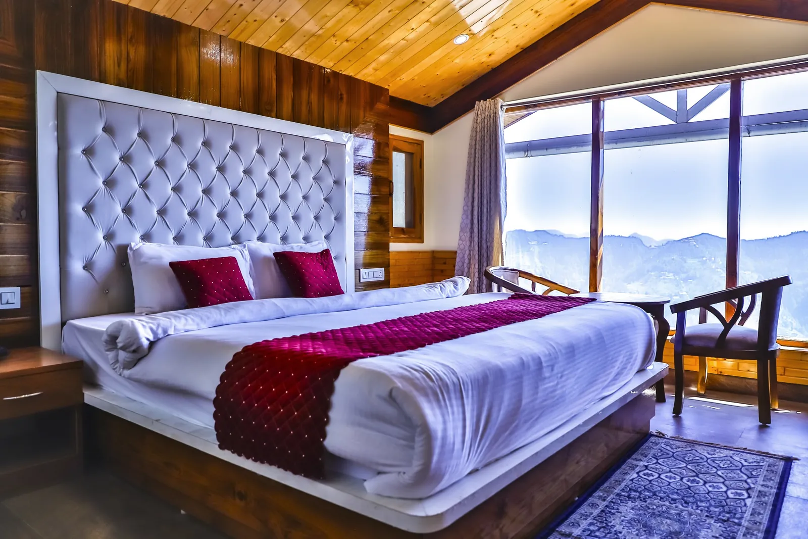 Deluxe Room bed facing a wall of windows
