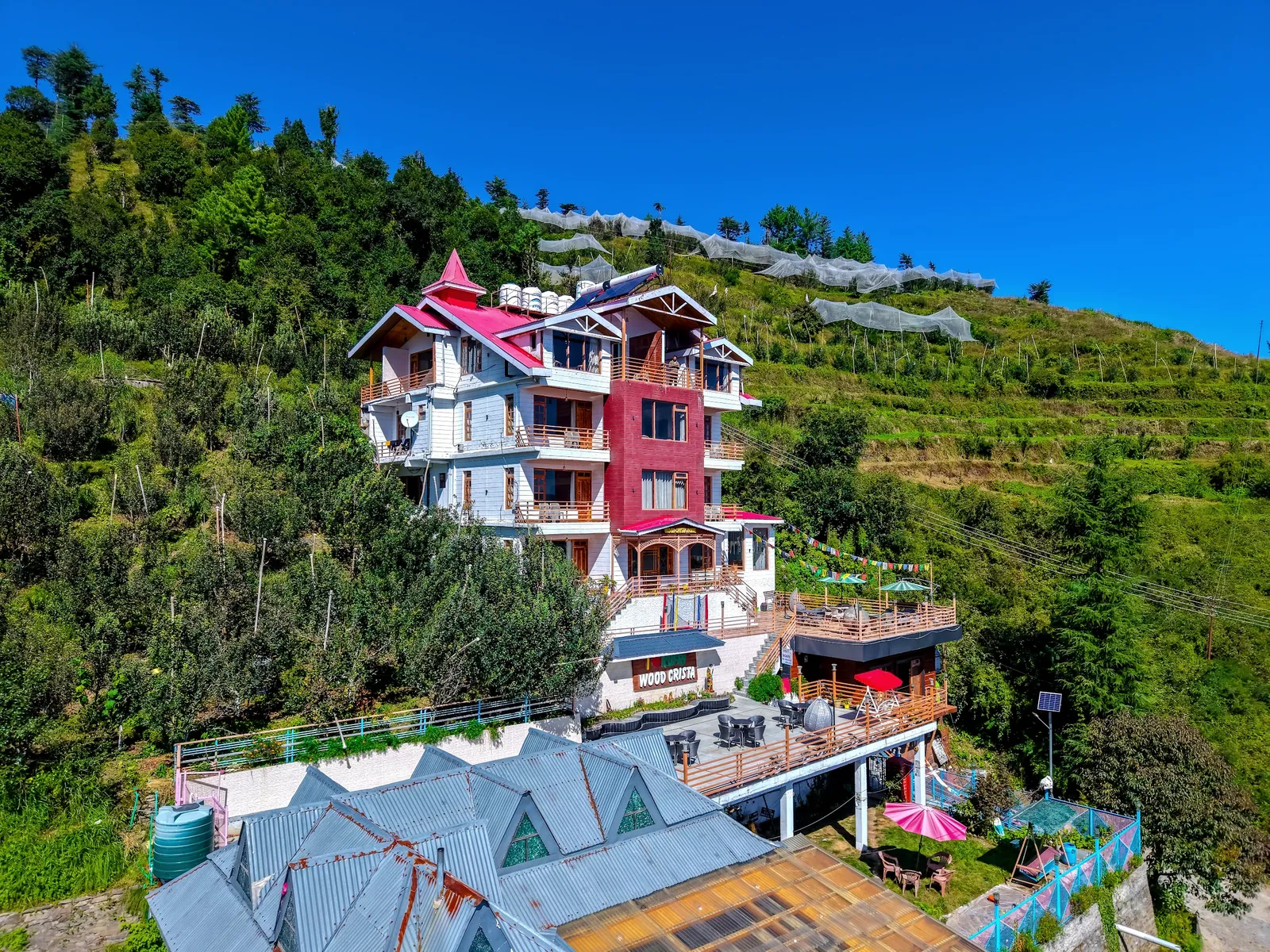 Wood Crista seen from the air, red roofs against the orchard slope