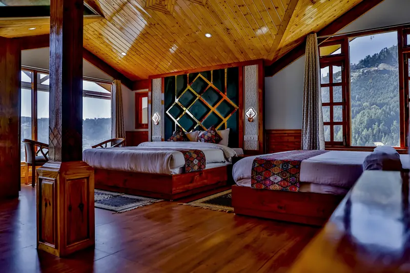 Orchard Suite: two beds under a vaulted pine ceiling